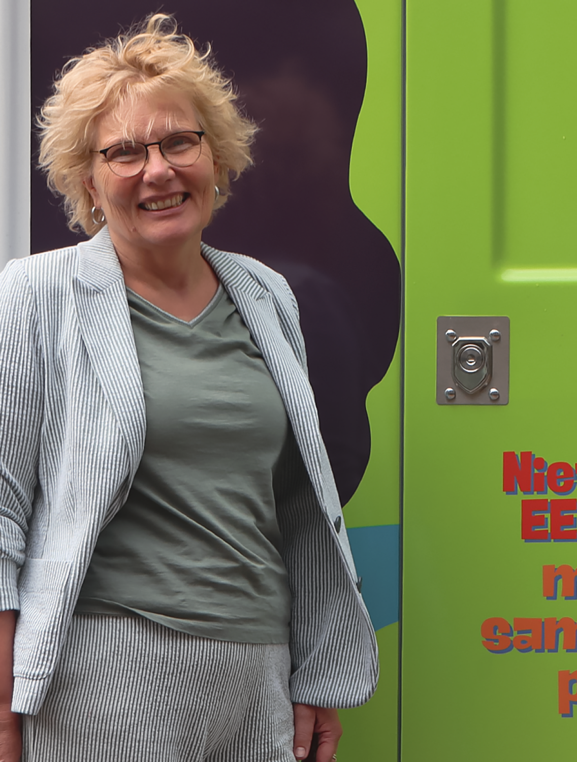 Persoon in een groen shirt voor een kleurrijke bus